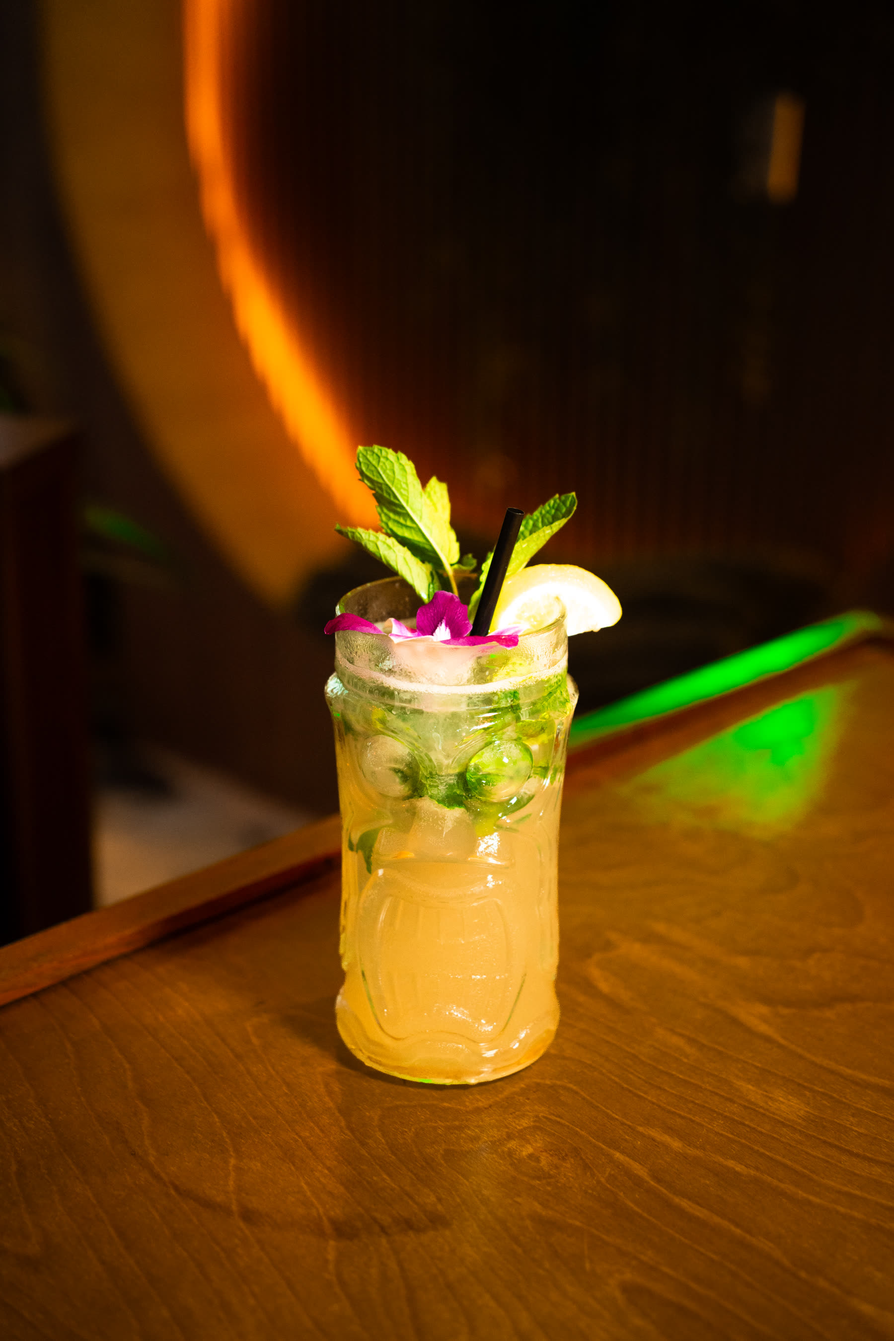 Cocktail with mint and orchid garnish