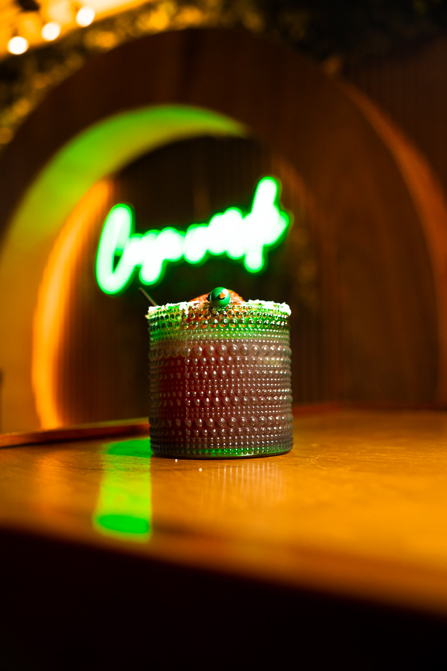 Cocktail in hobnail glass with neon glow